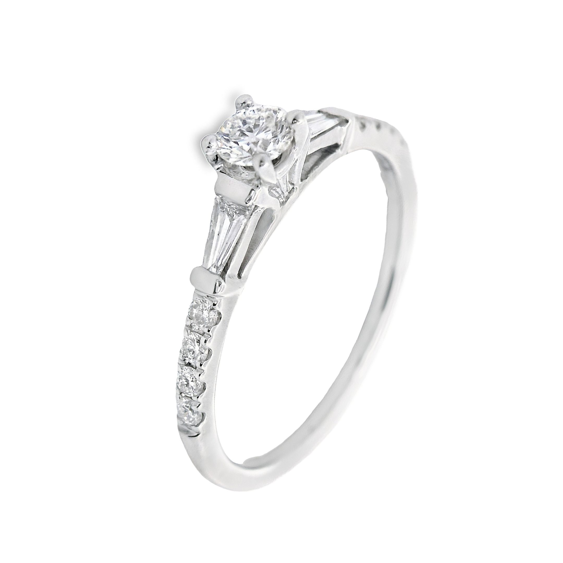 Deze exclusieve ring van Louis Bros is vervaardigd uit 14 karaat witgoud (2.18 gr.) en is gezet met 2 baguette 0.23ct en 9 briljant geslepen diamanten met een totaalgewicht van 0.27ct. De ring heeft een diameter van 3.5 mm, minimale breedte van 1.7 mm. en een hoogte van 5.5 mm. Een witgouden solitaire ring met een diamant in het midden en twee baguette diamanten aan de zijkanten is echt adembenemend. Deze ring straalt elegantie en verfijning uit, met een tijdloos ontwerp dat de aandacht trekt. Het sprankelende middelpunt en de subtiele baguette diamanten zorgen voor een perfecte balans van glamour en stijl. Het is de ideale ring om je liefde en toewijding te symboliseren.
De ring is verkrijgbaar in meerdere afmetingen.

Verkrijgbaar vanaf 0.25crt .
Leverbare goudkleuren: 14/18kts geelgoud, 14/18kts witgoud, 14/18kts roségoud en alle bicolor combinaties.